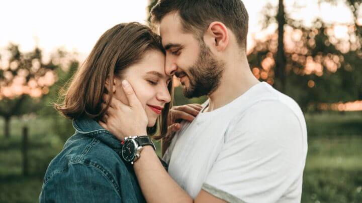 Casal em um parque com os rosto colados