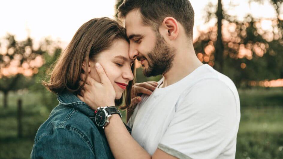 Casal em um parque com os rosto colados