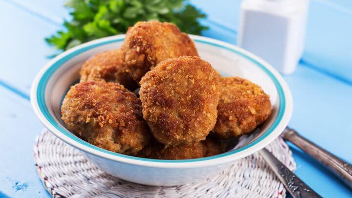Recipiente azul e branco com bolinho de frango frito