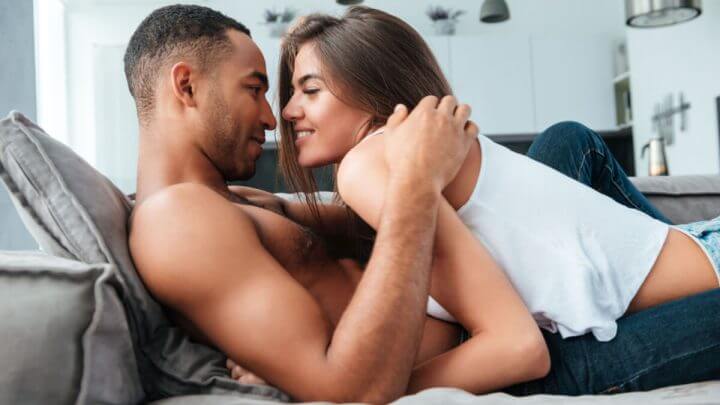 Casal na cama olhando um para o outro