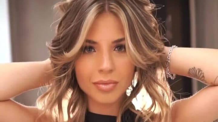Mulher com as mãos nos cabelos posando para foto