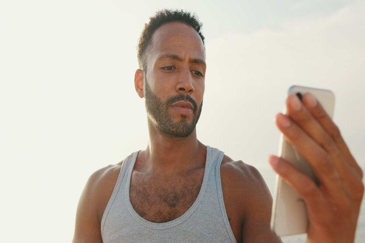 Homem mexendo em um celular