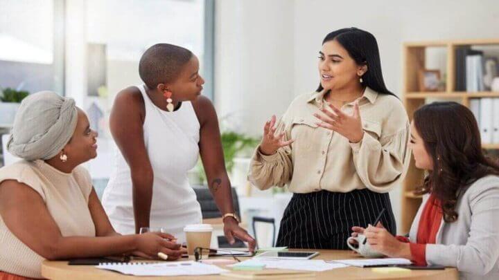Pessoas sentadas em uma mesa de reunião conversando