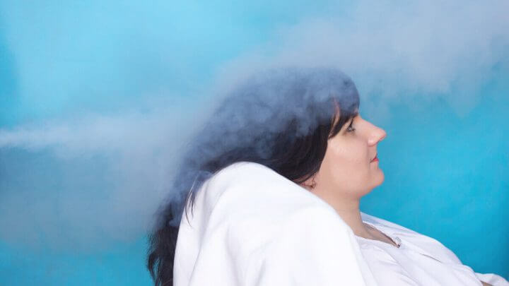 Mulher deitada recebendo vapor nos cabelos