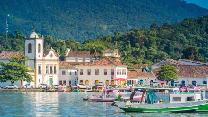 Vista da cidade de Paraty, com barcos no mar e Igreja ao fundo.