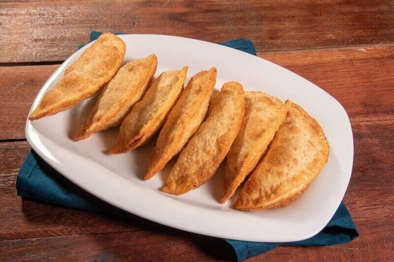 Prato branco com pastéis em cima de uma mesa de madeira
