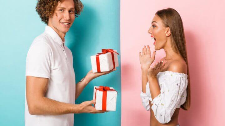 Homem segurando dois presentes e uma mulher surpresa
