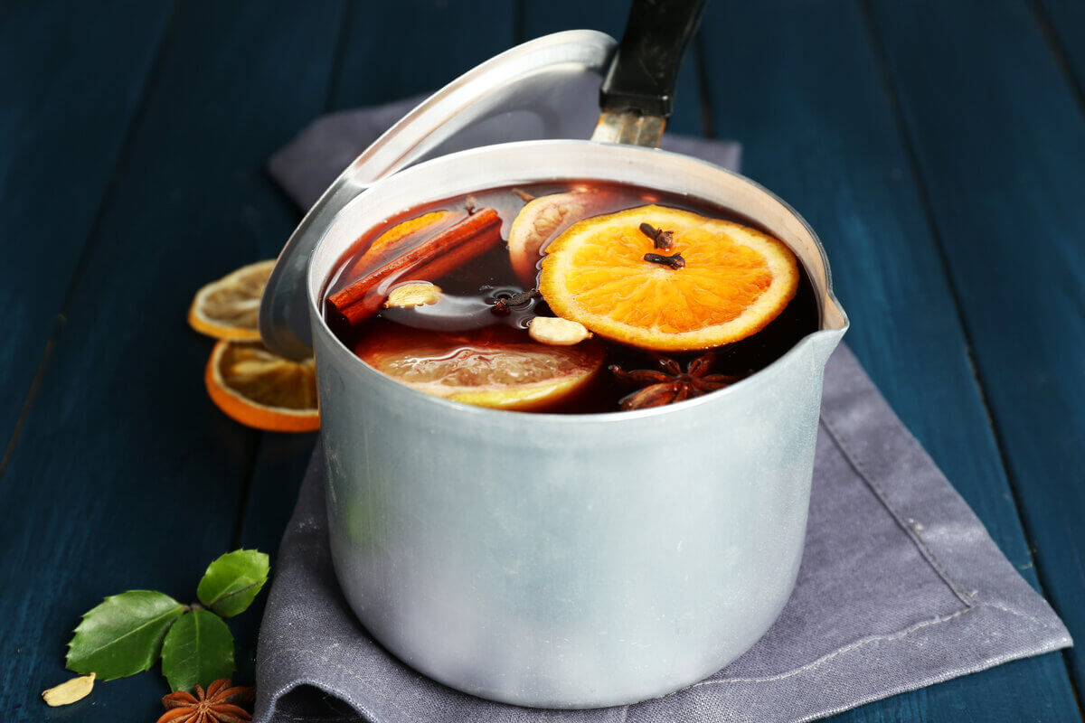 Panela com quentão de vinho, rodelas de laranja, cravo e canela