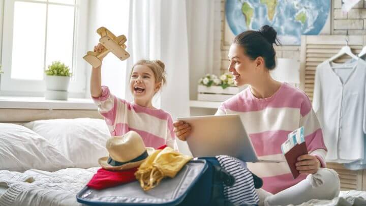 Menina e mulher sentada em uma cama vestindo blusas iguais