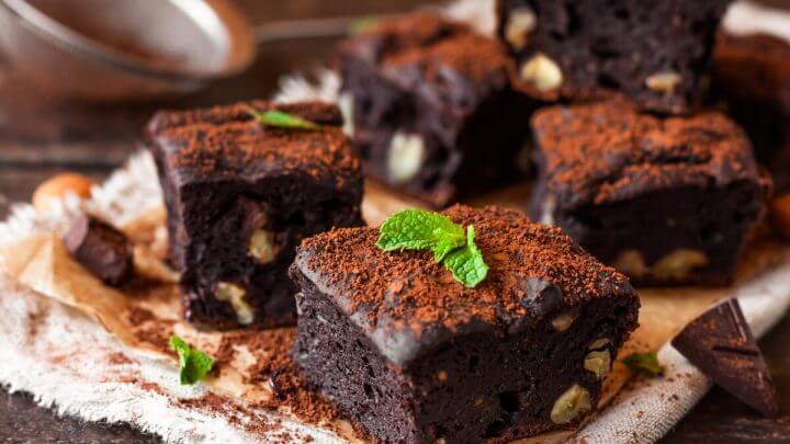 Brownies em cima de um pano branco decorados com folhas de hortelã