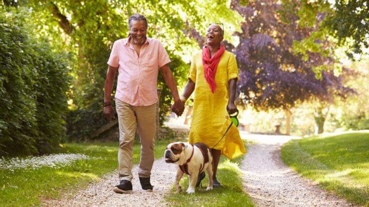 Casal de idosos passeando com cachorro