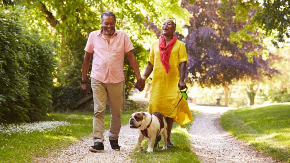 Casal de idosos passeando com cachorro