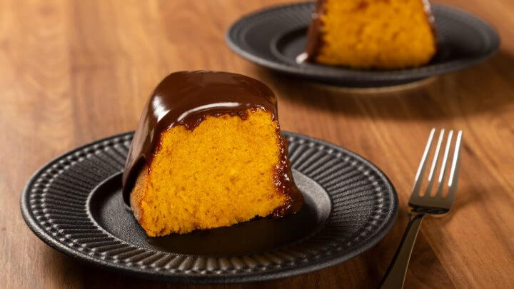 Pedaço de bolo de cenoura com chocolate em um prato preto