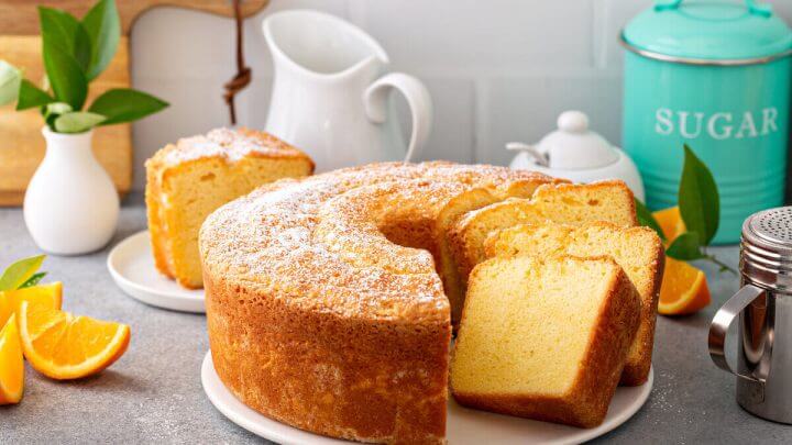 Bolo de laranja em cima de um prato branco cortado em pedaços