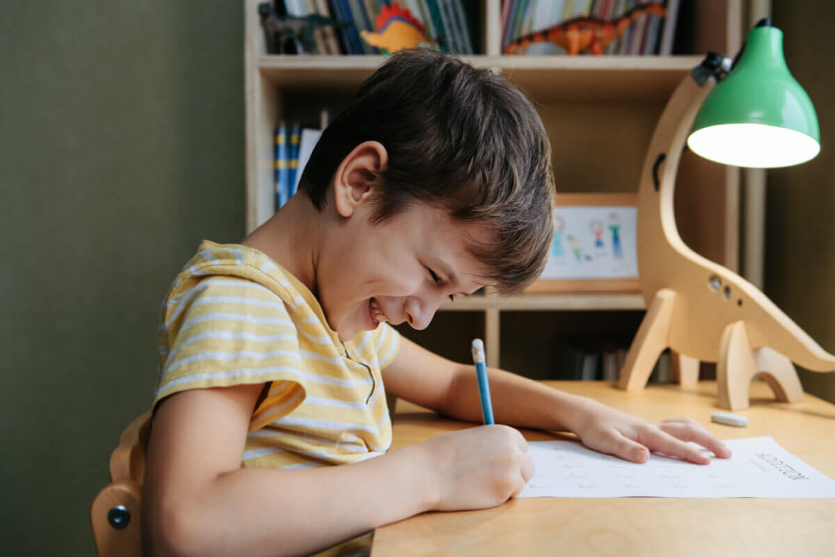 Menino desenhando em uma folha de papel