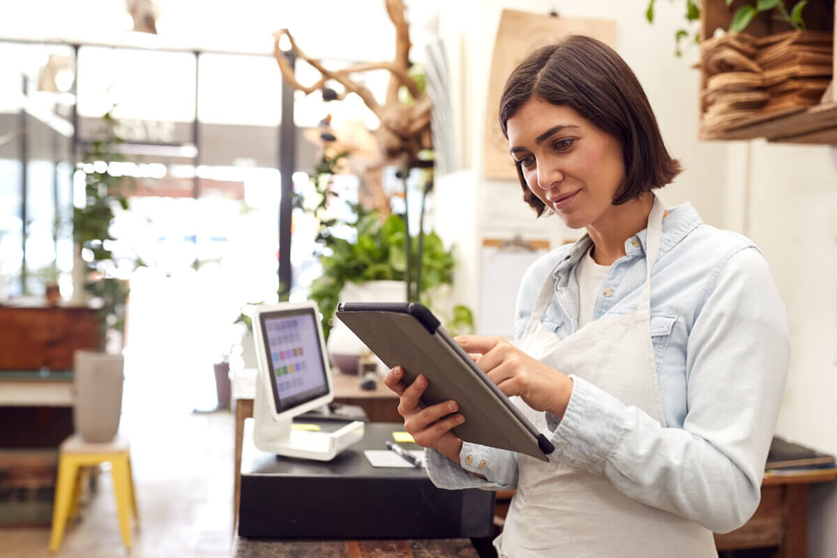 Mulher vestindo um avental e mexendo em um tablet