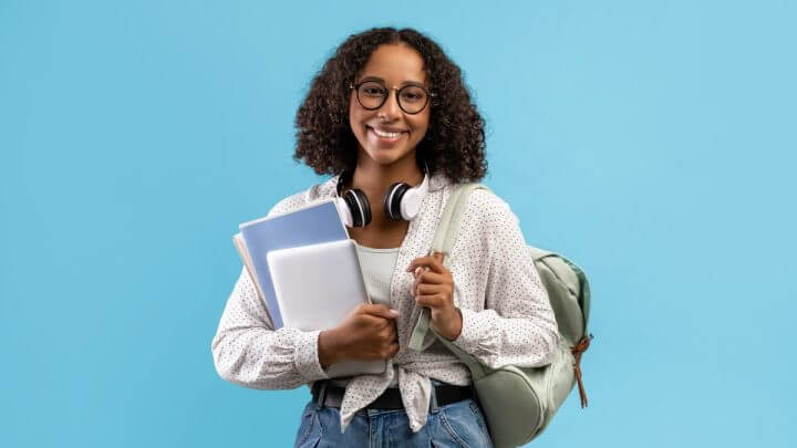 Mulher usando óculos sentada estudando em frente a um computador