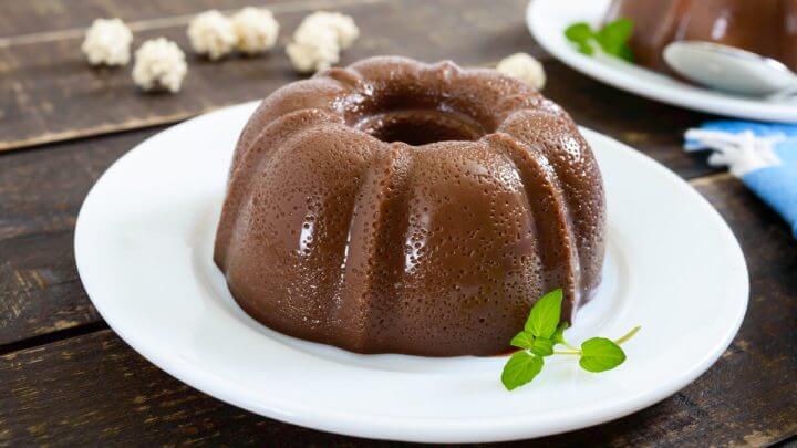 Prato branco em cima de uma mesa com pudim de chocolate