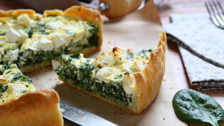 Pedaços de quiche com recheio de espinafre e tofu em cima de uma mesa de madeira