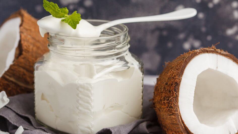 Recipiente branco com requeijão de coco e uma colher